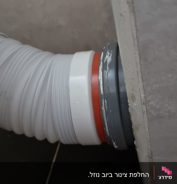 צינור פלסטיק לבן מחובר לקיר אפור
